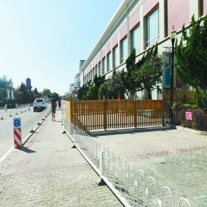 龙城花园小区幼童园搭木栅栏圈占人行道