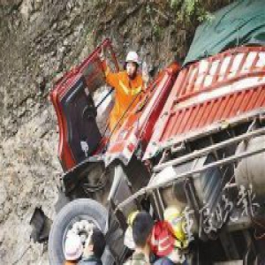 大货车撞崖 消防战士左手举输液瓶右手扶车门
